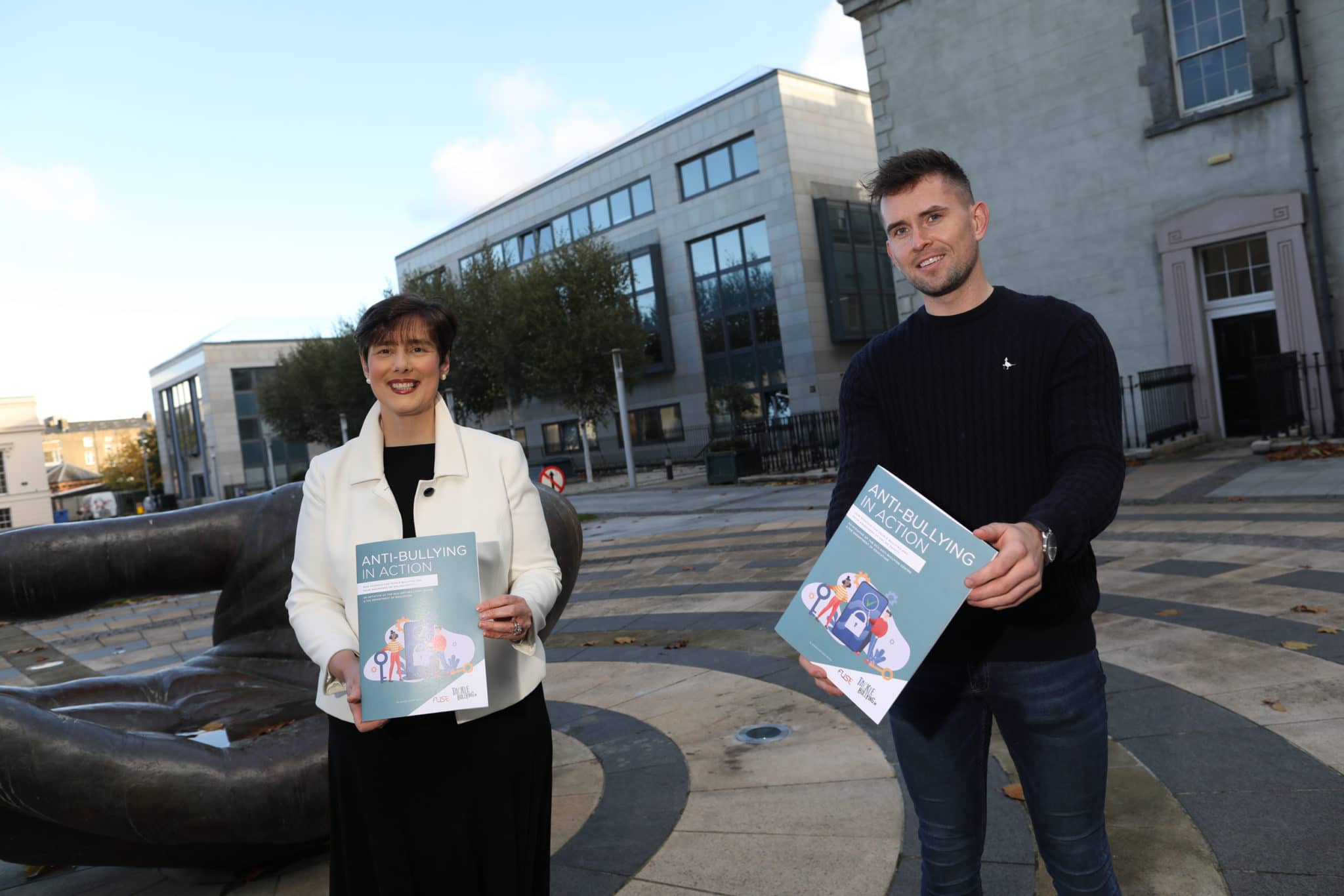 This is a photo of Norma Foley TD and Colm Canning. They holding booklets titled "Anti-Bullying in Action" towards the camera.